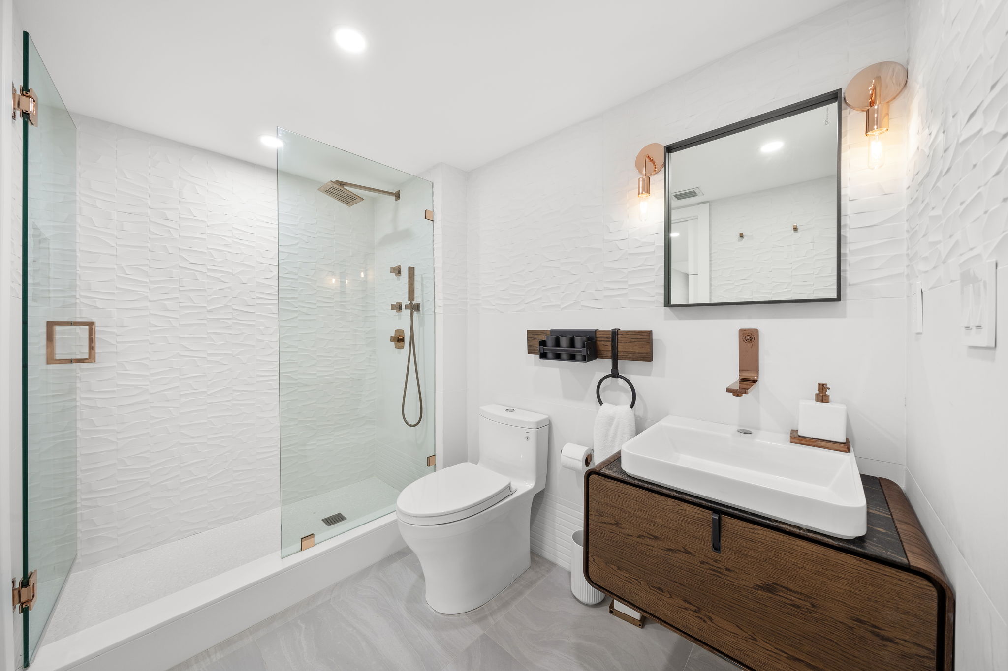 Guest bathroom with textured white tile and rose gold fixtures